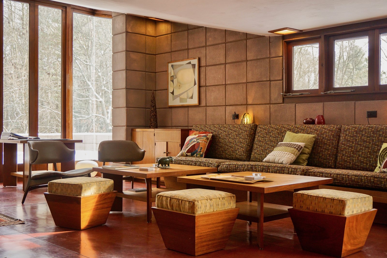 The original built in sofa remains in the Living Room. Ten foot windows draw nature inside while Maharam and Knoll textiles decorate the furnishings.