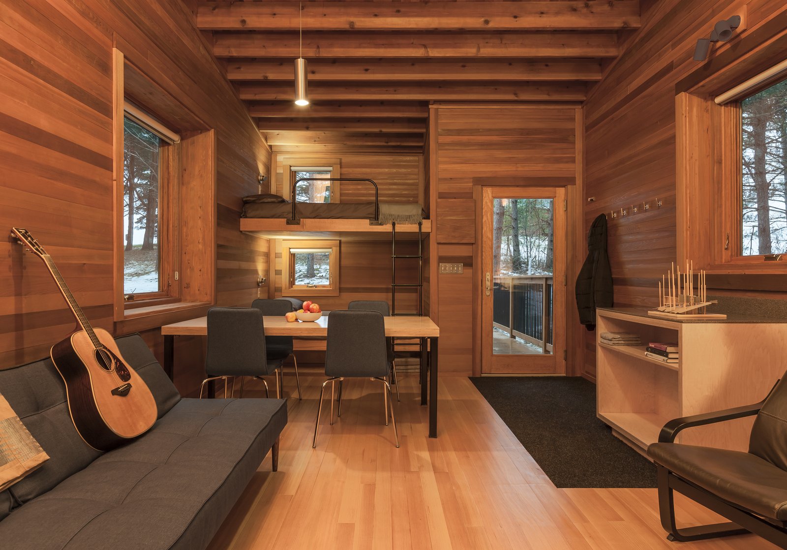 Built-in bunks are decked out with a private window for viewing the outdoors, and an adjustable reading light from Prima Lighting. A simple pendant hangs above the main space.