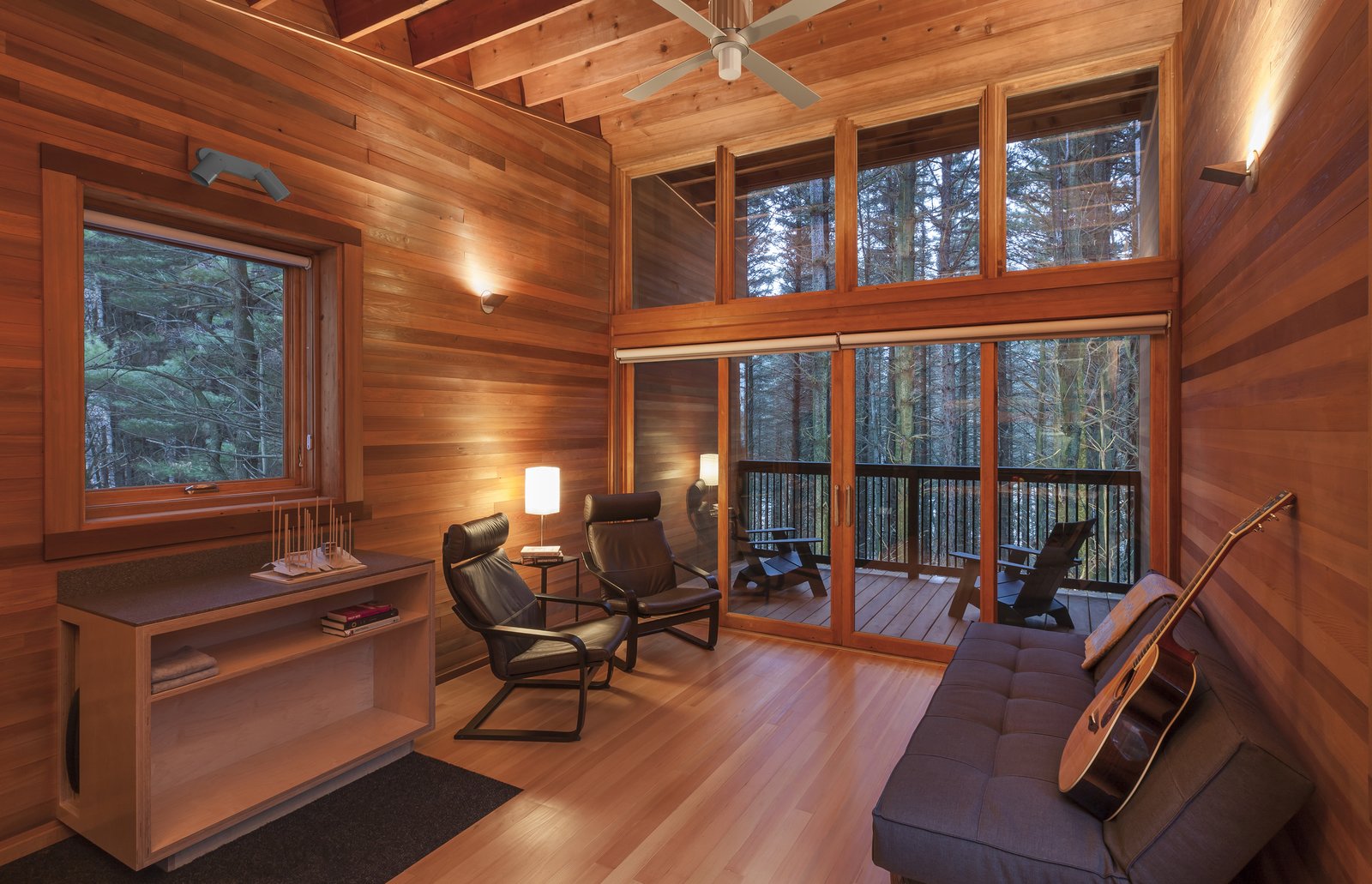Cedar wood seamlessly extends from inside to outside, creating a continuous extension to the woods beyond. Adirondack chairs provide the perfect viewing point from the balcony.