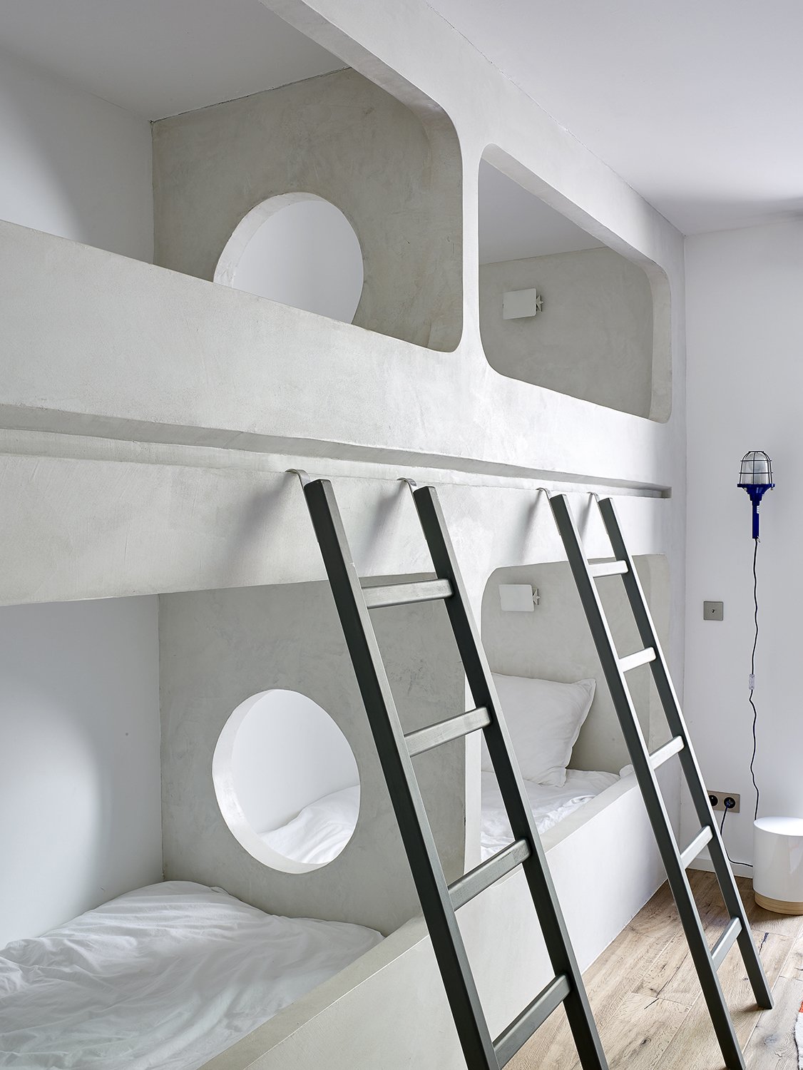 Custom bunk beds are built into one of the guest bedrooms. A circular opening is a playful addition.