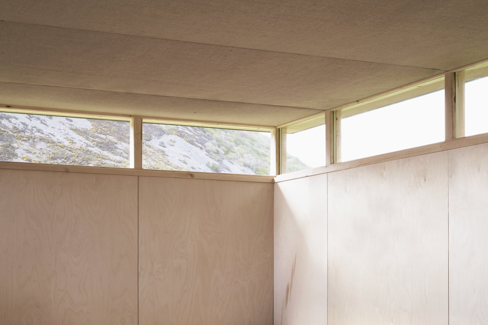Continuous windows draw daylight deep into the space, while providing views of the distant landscape and sky beyond.