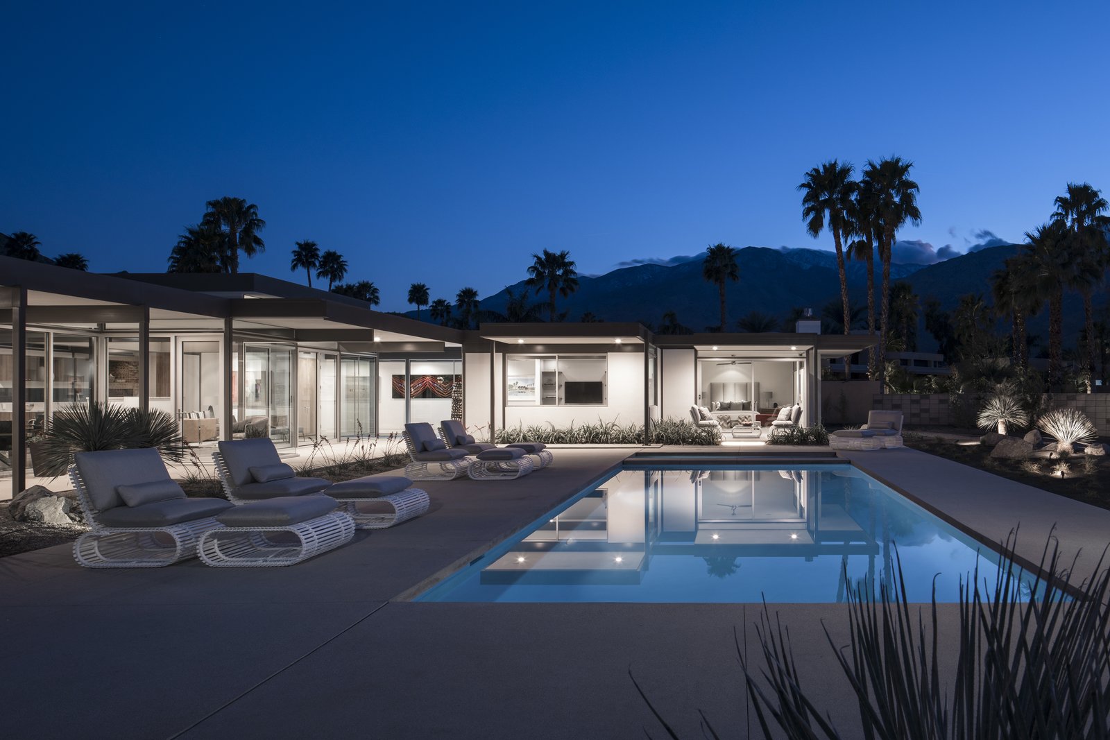 At dusk, the lightly colored home glows like a lantern in the dessert sky.