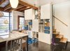 Modern home with dining room, ceiling lighting, table, storage, and chair. One of the major features of the project was a new cabinetry unit spanning the stairway between the living room and kitchen. This full-height unit now houses their collections, hobbies, books, as well as essential everyday items. The mix of opened and closed storage provides a mix of function and aesthetics, keeping clutter out of sight, but breaking up what could have otherwise been an overpowering monolithic structure. Photo 8 of Modern Mix