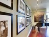 Modern home with Hallway and Medium Hardwood Floor. John is an avid world traveler and photographer. He took these photos (left) on one of his journeys to Thailand. We had them framed and hung in this bold arrangement. The Galen Garwood painting at the end of the hall was from their previous home. Originally, its frame was painted a light mauve, reminiscent of the 80s, so we chose to re-paint the frame an espresso/black. The small change brought the whole piece up-to-date. Photo 14 of Downsize Upstyle