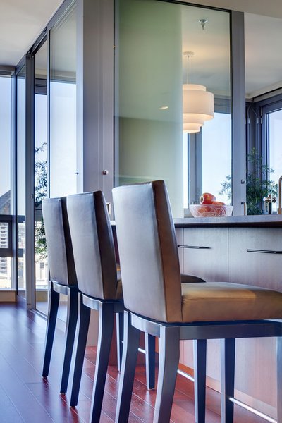 Modern home with dining room, stools, bar, medium hardwood floor, and ceiling lighting. Stools from A.Rudin sit at the kitchen island. Photo 20 of Downsize Upstyle