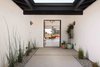 Modern home with outdoor, walkways, grass, concrete patio, porch, deck, pavers patio, porch, deck, and hanging lighting. Natural light and a thoughtful use of color knit everything together at 2222 Via Tiempo. The dasMOD team are designers at heart. Specificity is reflected at all scales, from the whole scale of the property down to the minute details; the cabinetry, specific tiles, hardware, and lighting choices throughout creating a true showcase for designer professionals and enthusiasts alike. Photo 14 of Via Tiempo