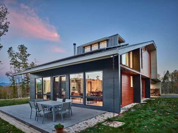 Modern home with outdoor, front yard, grass, hardscapes, small patio, porch, deck, and concrete patio, porch, deck. With solar panels in mind, the Charlottesville VA architects designed the roof for southern exposure and the incline to optimize the maximum potential for energy production. The solar panels produce 100% of the home’s energy needs through an 8 KW array system. The solar panels serve 100% of the homes needs. Excess energy is sold back to the local service provider. The Owner also accrues credits for those cloudy days when the panels are not producing energy. Photo 2 of Mill Pond House