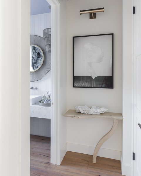 The hall is meant to be fresh and modern yet stay true to the Napa organic feel. I custom designed the wall-mounted table. The live edge and one curved leg in a bleached wood, feels both modern and in tune with nature. I love the Artwork by Simon Breitbard (artist Jennifer Brandon) because the black and white simplicity of her photography in this piece is again, both modern and simple. Photo 4 of Traditional Home Napa Valley Showhouse modern home