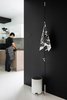 Modern home with Kitchen, Porcelain Tile Floor, White Cabinet, Granite Counter, Stone Tile Backsplashe, Ceiling Lighting, and Drop In Sink. The aesthetics of Norm Architects is minimalistic, functional and meets real-life needs. Even the dust bin designed by Jonas Bjerre-Poulsen and Kasper Rønn of Norm Architects for Menu may incite receptacle envy. The glossy white lacquered steel bin is matched against a black wall along the entryway to the kitchen. The Wardrope designed by Veronica Wildgruber and Susan Stofer for Authentics has an interesting design with a polyamide rope hanging from the ceiling and metal hooks sliding along it. The beautiful Veljekset pattern kitchen towel by Marimekko was a flawless addition on these hooks. Marimekko, the Finnish label that inspires with their bold use of colors and patterns, creates a striking contrast with the black & white Räsymatto pattern by Maija Loukari, expressed through various materials and objects at home, from textiles in kitchen to ceramics in living room to floor mats in bathrooms. Photo 11 of Living in Monochrome, far away from Nordic lands