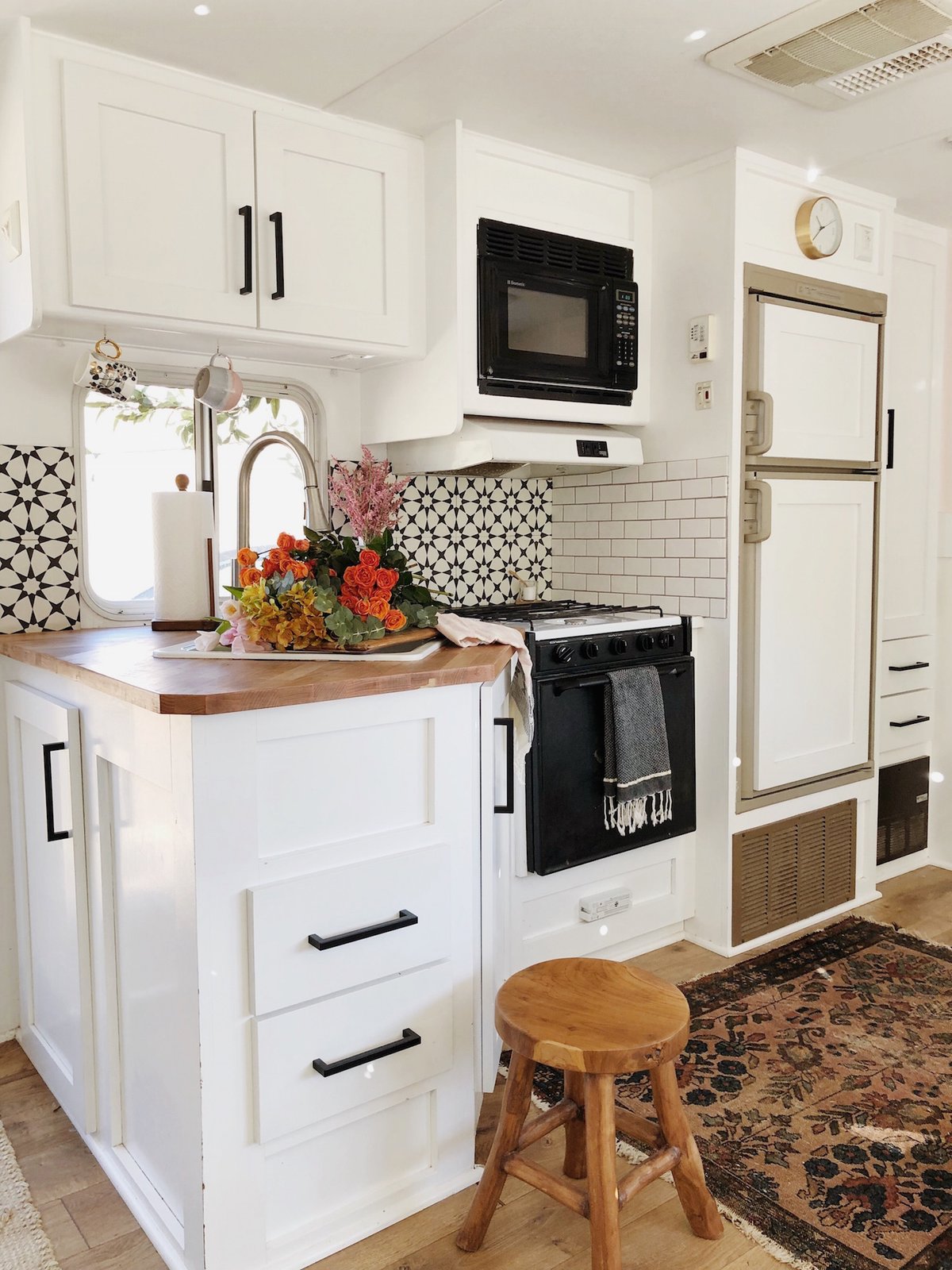 The compact kitchen features a ceramic tile backsplash.