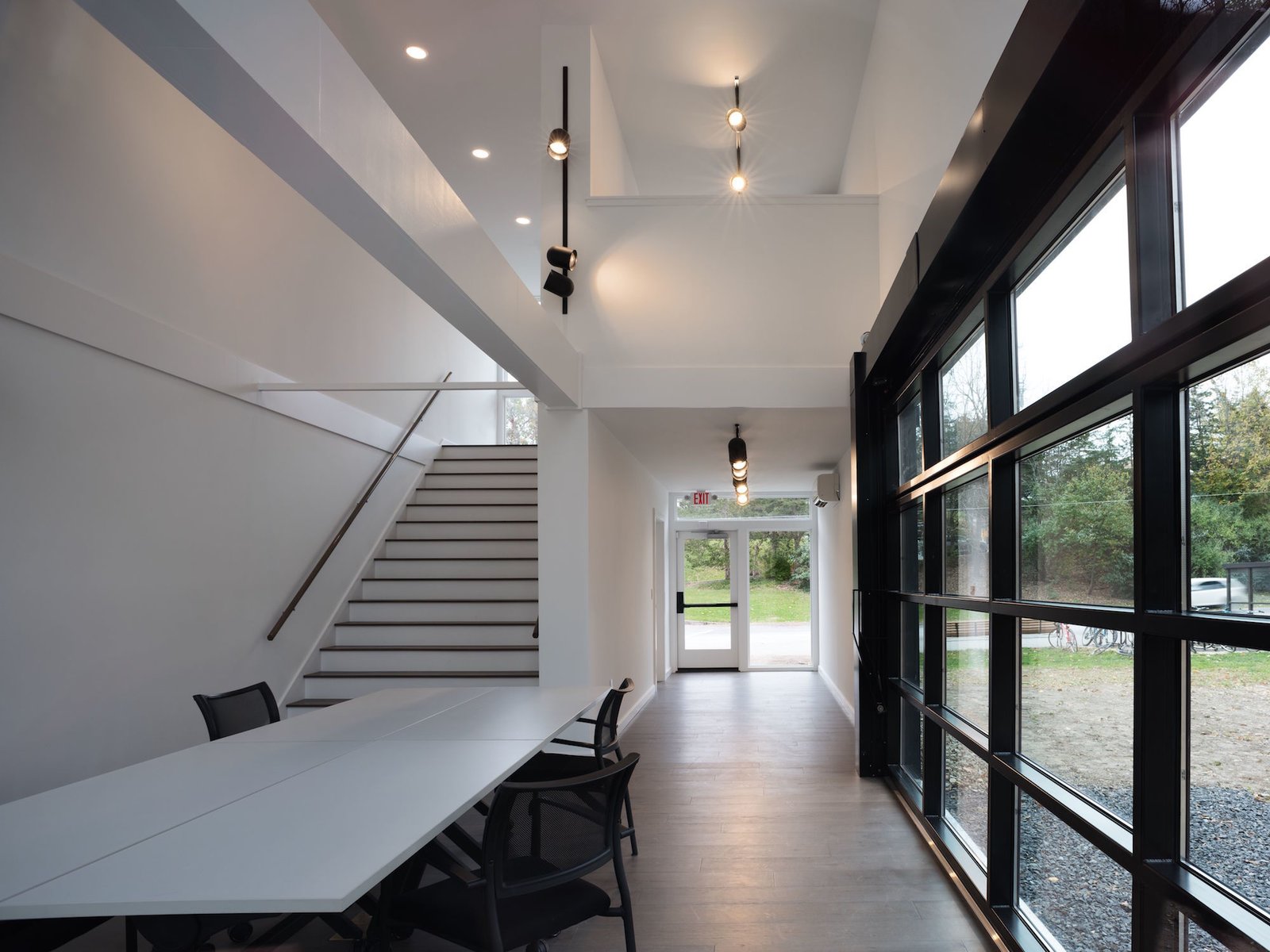 Stairs lead up to a small loft-like office that overlooks the meeting room below.