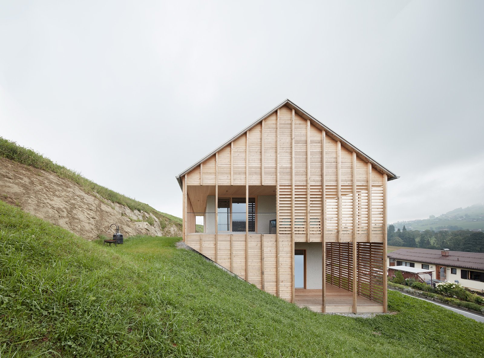 The gabled roof ridge is parallel to the hill.