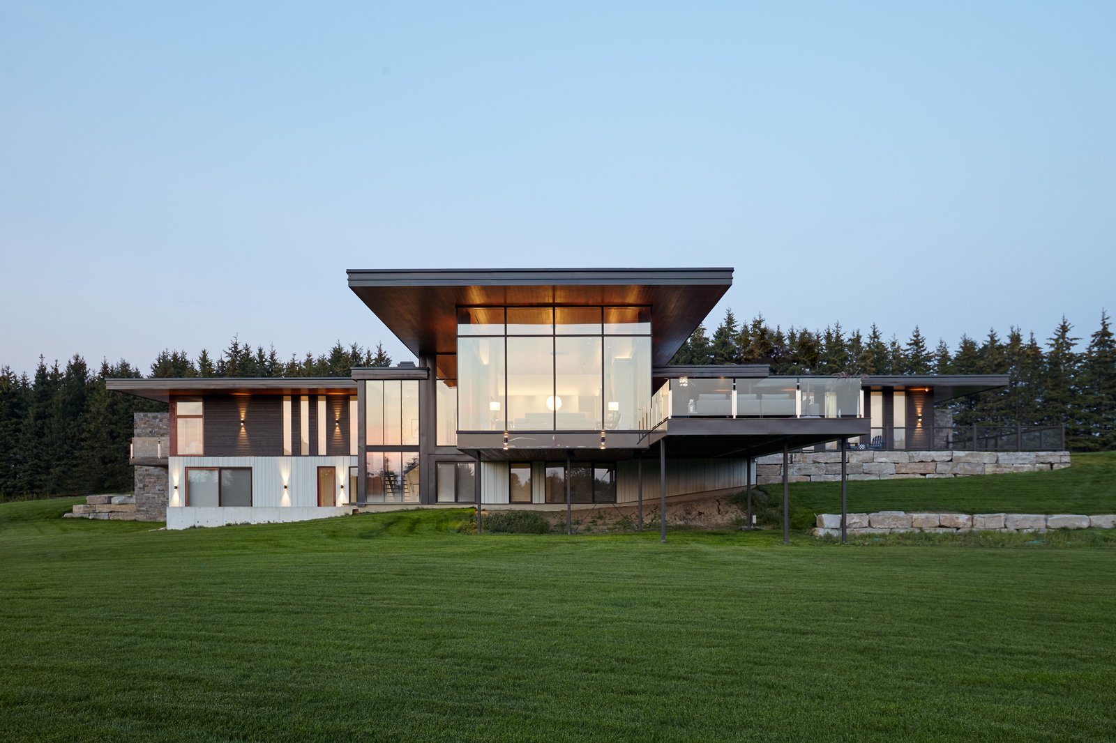 Rear view onto vast landscape with strong lines, custom curtain wall and large overhangs to protect form the sunlight