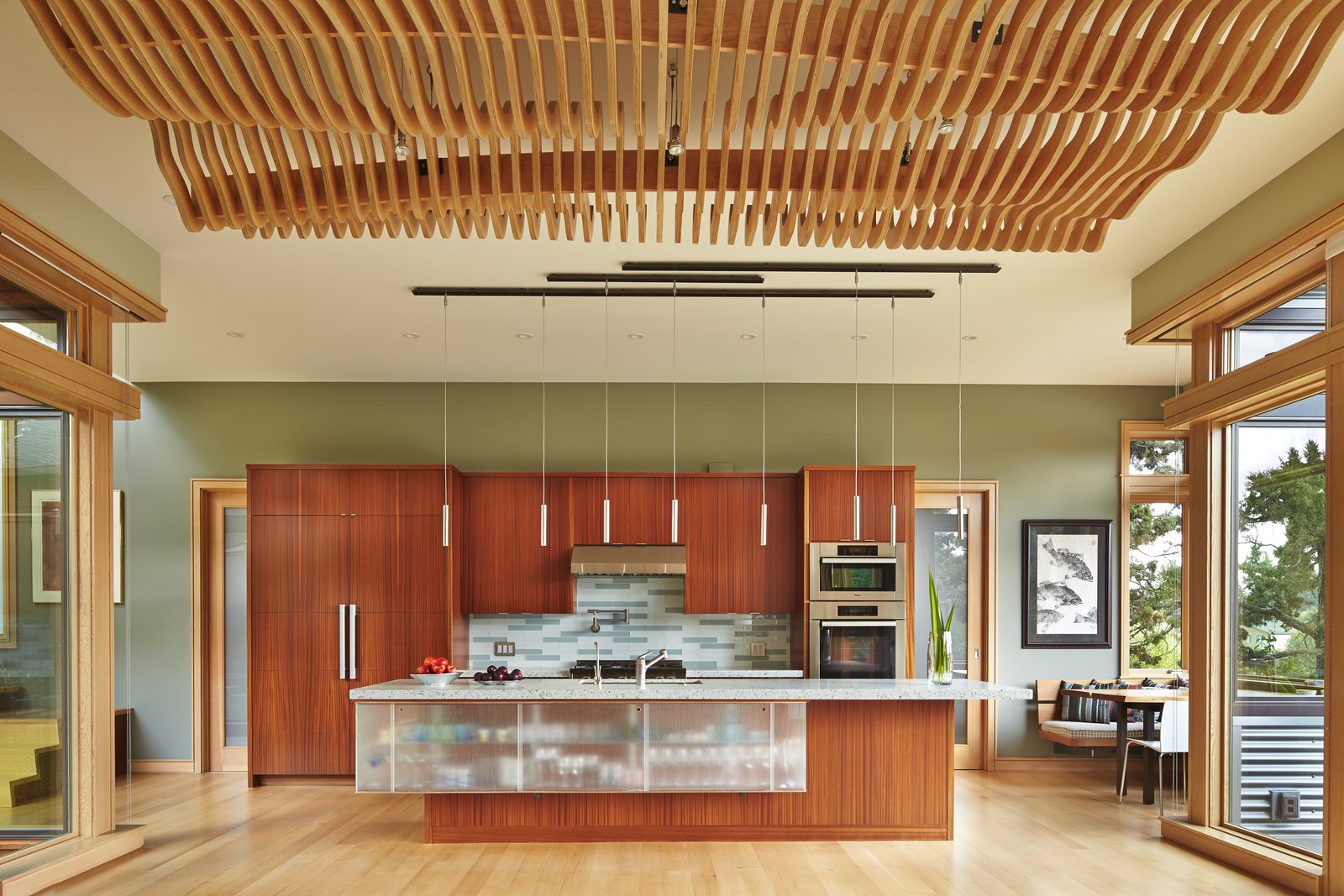 Kitchen with undulating wood screen ceiling over dining area