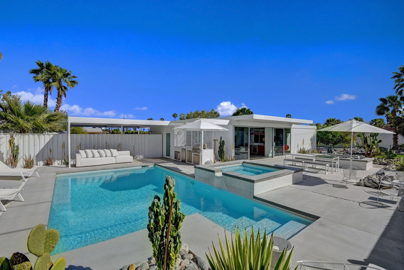 Facing east from pool and spa to outdoor kitchen and house.