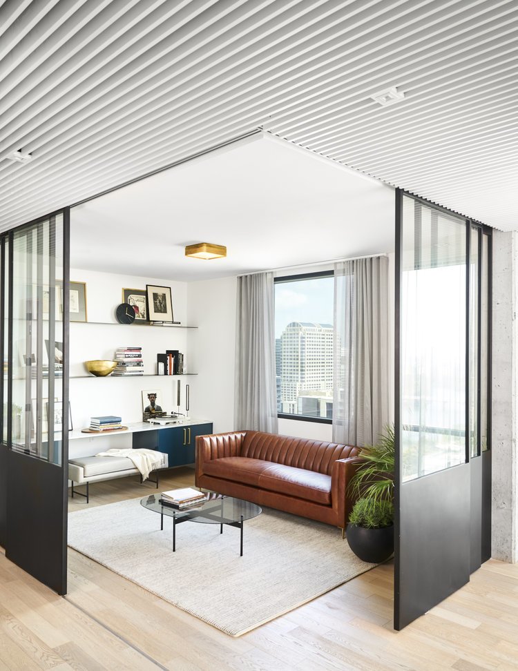 Steel & Glass Retractable Wall Panel in the Office: Robert wanted a space that could function as an office but still open up to the rest of the unit. We designed these custom glass and steel doors on a retractable sliding track, allowing the space to function as either a private or public space.