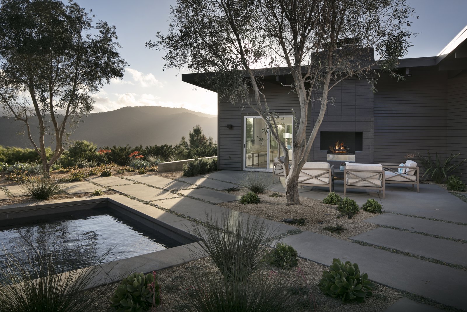 Another perspective of the home's rear exterior including an outdoor fireplace.